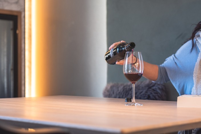 Ein Glas Wein im Design Apartmenthaus einschenken