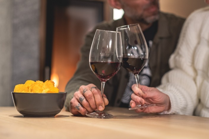 Im Apart Herzog Wohnbereich ein Glas Wein und Chips genießen