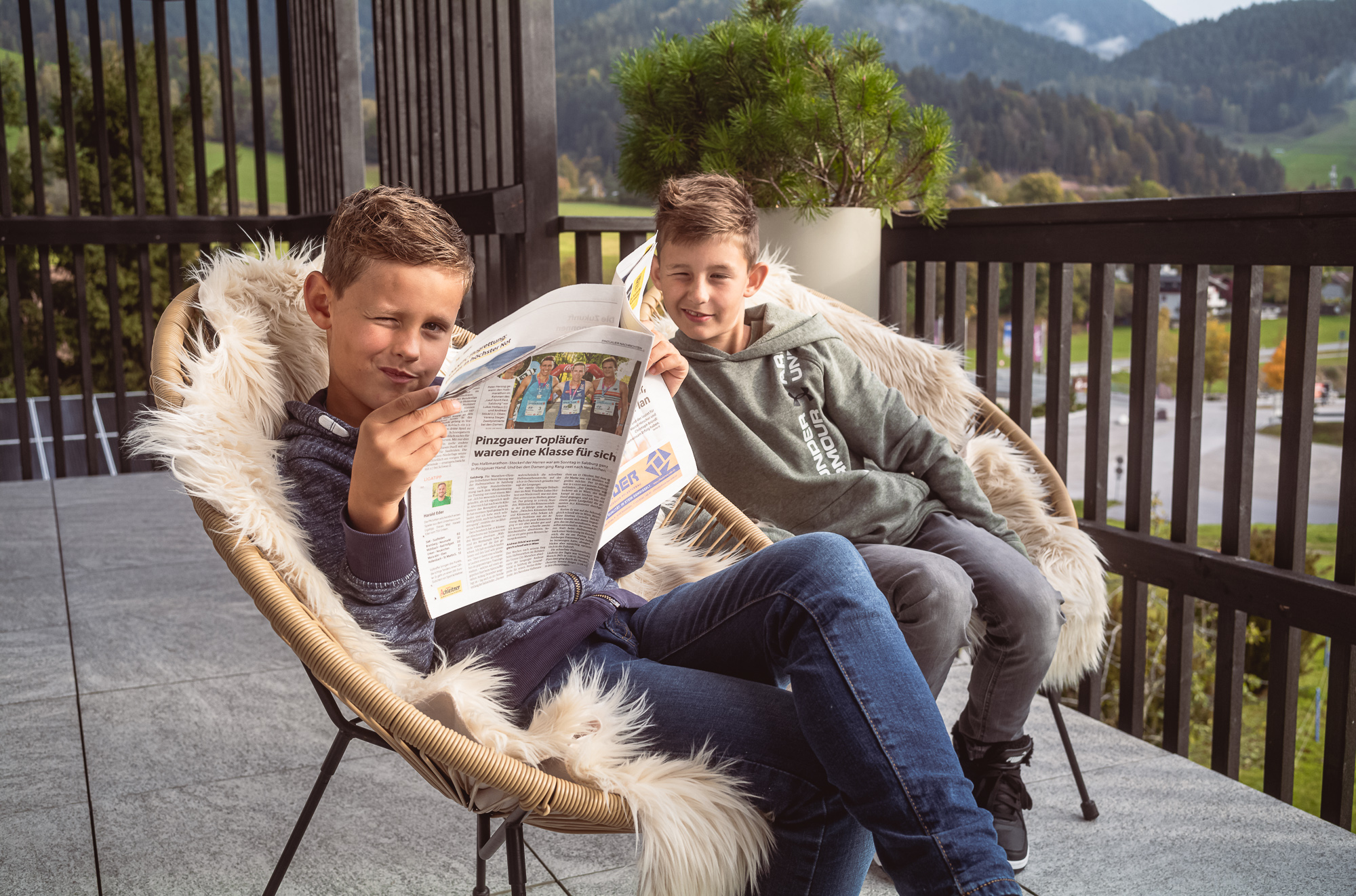 Kinder auf Terrasse Penthouse Apart Herzog beim Zeitunglesen