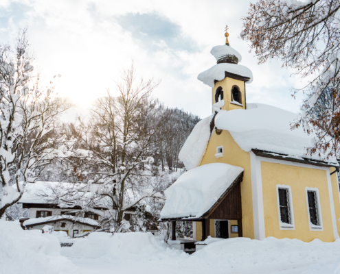 Wohnung in den Bergen bedeutet auch eine verschneite Kirche